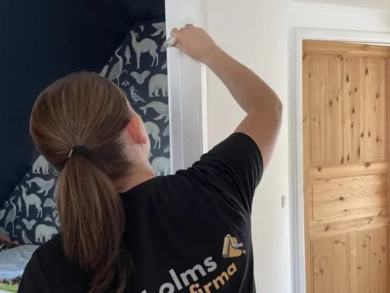 Person maler dørkarm i bolig