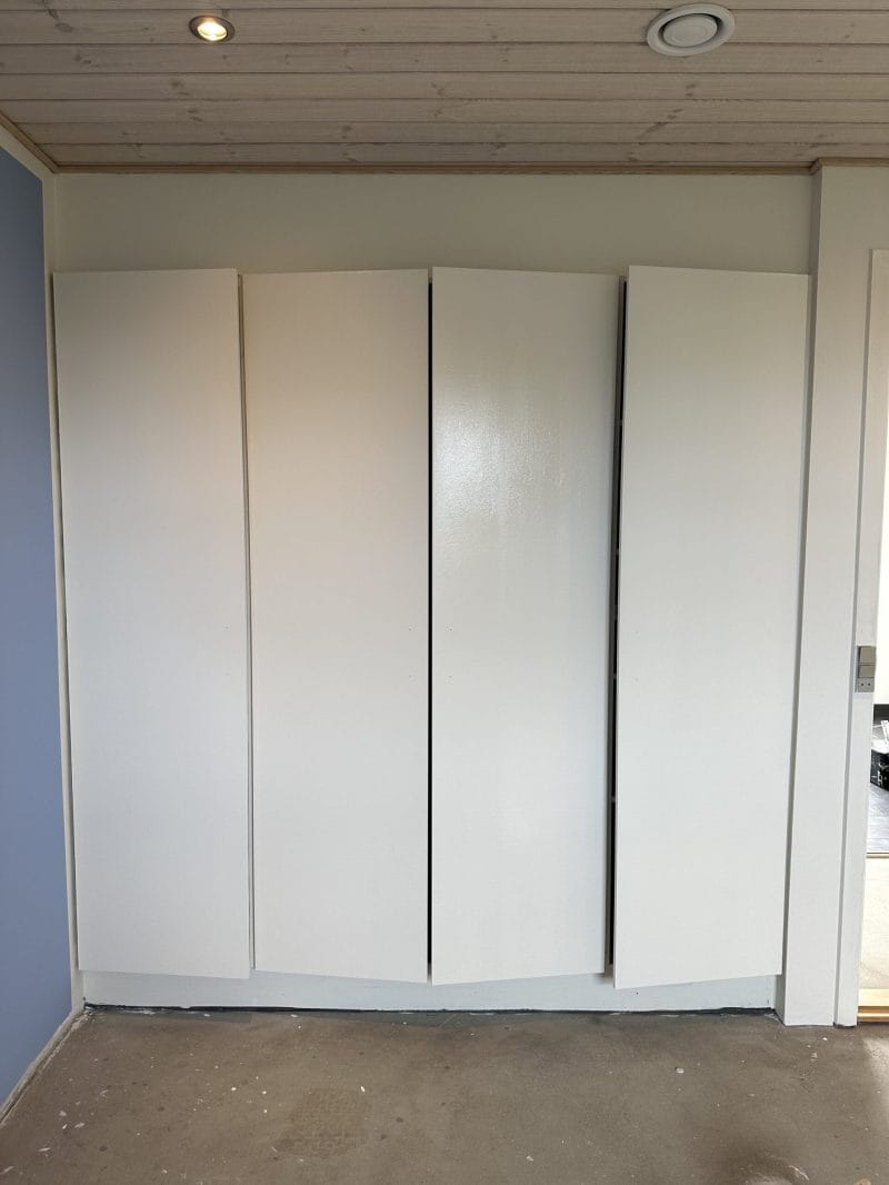 Hvidt indbygget skab mod væg i moderne rum